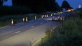 Roadworks cones flashing on UK motorway at night with traffic passing Royalty Free Stock Photo