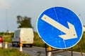 Roadworks directional arrow sign on UK motorway at evening with traffic passing