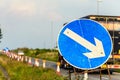 Roadworks directional arrow sign on UK motorway at evening with traffic passing