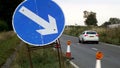 Roadworks directional arrow sign on UK motorway at evening with traffic passing