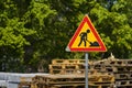 Roadworks warning sign with wooden pallets in the background Royalty Free Stock Photo