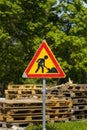 Roadworks warning sign with wooden pallets in the background Royalty Free Stock Photo