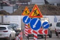 Roadworks warning traffic signs of construction work on city street and slowly moving cars Royalty Free Stock Photo