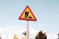 Roadworks yellow red triangular sign on street. Temporary construction icon Royalty Free Stock Photo