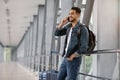 Roaming Abroad. Portrait Of Handsome Arab Man Talking On Cellphone In Airport Royalty Free Stock Photo