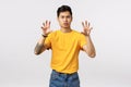 Roar hot staff. Cheeky and handsome stylish asian man in yellow t-shirt, making paw gesture as if squeezing something or Royalty Free Stock Photo