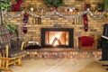 Roaring fire in a vinrage brick frieplace decorated for Christmas, with piano, rocking chair and cozy decor Royalty Free Stock Photo