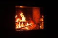 Roaring flames in a modern fireplace with shiny slate framing