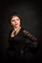 Roaring Twenties. Woman portrait in the style of Gatsby. Low key. Beautiful young woman in a black dress, satin gloves.