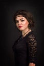 Roaring Twenties. Woman portrait in the style of Gatsby. Low key. Beautiful young woman in a black lace dress romantic looks. Royalty Free Stock Photo