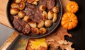 Roast beef steak with roasted potatos in copper pan on wooden table, top view. Royalty Free Stock Photo