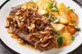 Roast Beef Zwiebelrostbraten with onions and fried potatoes Bratkartoffeln closeup on the plate. Horizontal Royalty Free Stock Photo