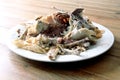 Roast chicken carcass remains on a plate on a wooden table