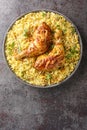 Roast chicken legs with fried onions served with spicy pilaf close-up in a plate. Vertical top view