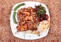 Roast chicken served on a white plate with green pepperoni and salad with fresh vegetables on a wooden table topped with spicy Royalty Free Stock Photo