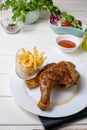 Roast chicken thighs and fries, and salad of lettuce and tomato Royalty Free Stock Photo