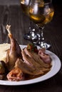 Roast duck on a plate, in a glass of whiskey. Photo of food on a dark background