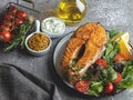 Roast, fried, baked fish steak salmon with fresh salad and tomatoes top view Royalty Free Stock Photo