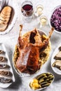 Roast goose with side dishes, red cabbage, roast, strudel, potato dumplings, pickles, bread and red wine Royalty Free Stock Photo