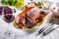 Roast goose with side dishes, red cabbage, roast, strudel, potato dumplings, pickles, bread and red wine. Traditional holiday food
