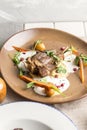 Roast Lamb leg with carrot, potato and pomegranate on brown plate on the table Royalty Free Stock Photo