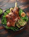 Roast Lamb leg with mint sauce, rosemary and garlic. on black plate, wooden table Royalty Free Stock Photo