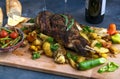 Roast lamb shoulder with roasted potatoes and carrots styled in a rustic wooden board, top view Royalty Free Stock Photo