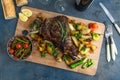 Roast lamb shoulder with roasted potatoes and carrots styled in a rustic wooden board, top view Royalty Free Stock Photo
