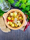 Roast meat and vegetables in clay pot on board top Royalty Free Stock Photo