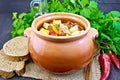 Roast meat and vegetables in clay pot on dark board Royalty Free Stock Photo