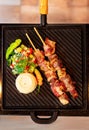 roast meat on wooden sticks with salad and flour. brazilian beef brochette Royalty Free Stock Photo