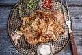 Roast pork with garlic, salt and red sauce on iron baking tray rusticwith fork on wooden rustic background, top view, close up