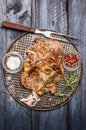 Roast pork with garlic, salt and red sauce on iron baking tray rusticwith fork on wooden rustic background, top view