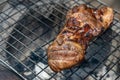 Roast pork neck on the stove with charcoal from wood Royalty Free Stock Photo