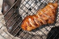 Roast pork neck on the stove with charcoal from wood Royalty Free Stock Photo