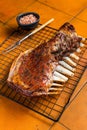 Roast Rack of lamb ribs, spareribs on grill. Orange background. Top view Royalty Free Stock Photo
