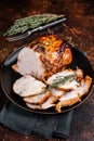 Roast rolled pork ham meat on plate with thyme. Dark background. Top view Royalty Free Stock Photo