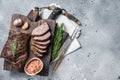 Roast and sliced tri tip beef steak on a wooden board with herbs. Gray background. Top view. Copy space Royalty Free Stock Photo