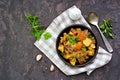 Roast, stewed beef with potatoes and carrots in a brown clay bowl on a dark concrete background Royalty Free Stock Photo