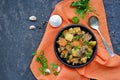 Roast, stewed beef with potatoes and carrots in a brown clay bowl on a dark concrete background