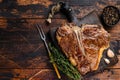 Roast t-bone or porterhouse beef meat Steak on a wooden cutting board. Dark wooden background. Top view. Copy space Royalty Free Stock Photo