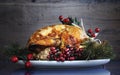 Roast turkey against dark rustic wood background.