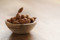 Roasted almonds falling in wood bowl on wooden table Royalty Free Stock Photo