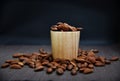 Roasted almonds in wooden cup and on napkin.