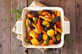 Roasted autumn vegetables in a baking dish, top view over rustic wood Royalty Free Stock Photo