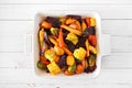 Roasted autumn vegetables in a baking dish, top view over white wood Royalty Free Stock Photo