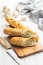 Roasted baguette with garlic butter. Crunchy sliced garlic bread on white table Royalty Free Stock Photo