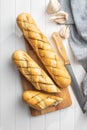 Roasted baguette with garlic butter. Crunchy sliced garlic bread on white table Royalty Free Stock Photo