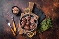 Roasted beef kidney, offal meat in skillet with herbs. Dark background. Top view Royalty Free Stock Photo