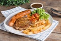 Roasted beef meat steak and sausage with french fries. Royalty Free Stock Photo